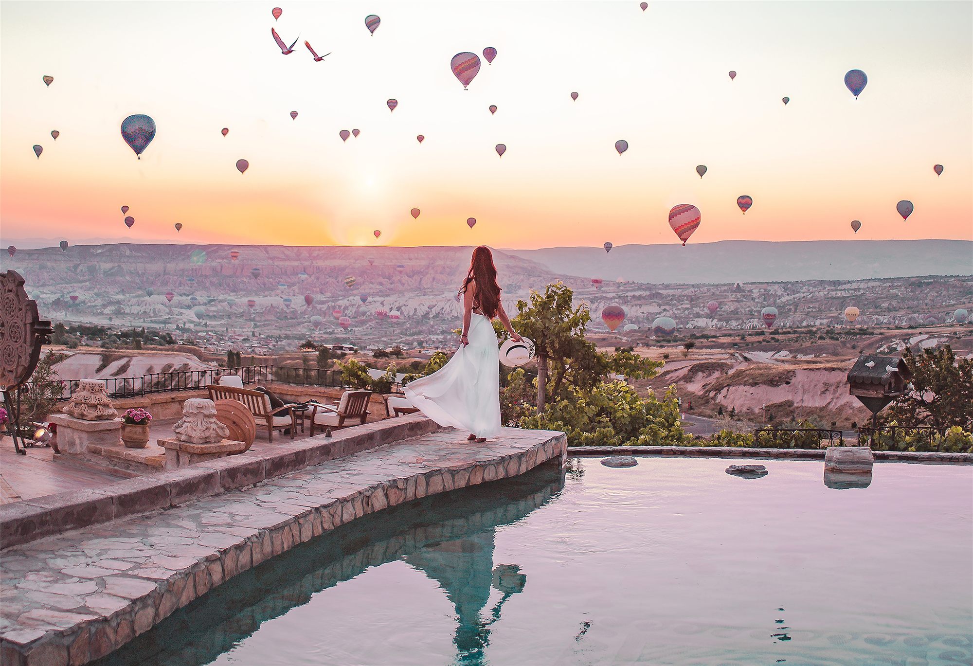 Museum Hotel pool with hot air balloons over Uçhisar, Cappadocia